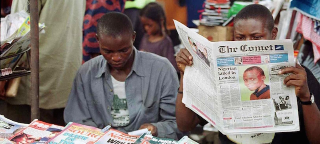 A newspaper vendor reads 30 November 2000 in Lagos the account of the death this week of 10-year-old Damilola Taylor, a Nigerian schoolboy brutally murdered in London. The news made frontpage news in most Nigerian newspapers. (Photo credit should read PIUS UTOMI EKPEI/AFP/Getty Images)