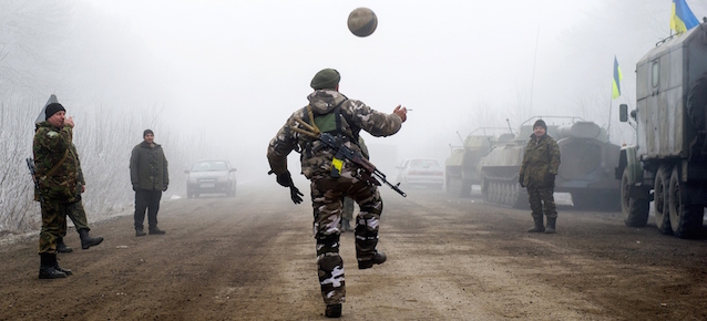 Ukrainian servicemen play football on a road at Svitlodarsk, approaching Debaltseve on February 15, 2015. A ceasefire in Ukraine was cautiously observed by both sides, despite accusations by Kiev and the US that Russia had fuelled a final push by rebels to gain territory before the deadline. Ukrainian President Petro Poroshenko ordered troops to abide by the truce from midnight (2200 GMT), in line with a deal reached in Minsk earlier this week with the leaders of Russia, Germany and France. AFP PHOTO/ VOLODYMYR SHUVAYEV (Photo credit should read VOLODYMYR SHUVAYEV/AFP/Getty Images)