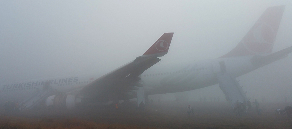 Passengers leave a Turkish Airlines plane which skidded off the runway on landing at Kathmandu airport in the Nepalese capital Kathmandu on March 4, 2015. Aviation officials said no one on board was injured, although one witness described how terrified passengers leapt from their seats as the cabin filled with smoke after the plane skidded to a halt. AFP PHOTO / Dikesh Malhotra (Photo credit should read Dikesh Malhotra/AFP/Getty Images)