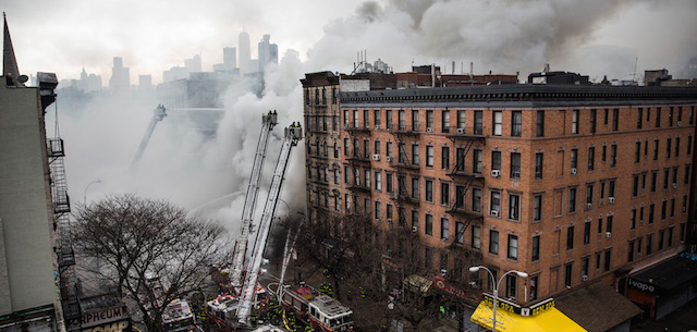 NEW YORK, NY - MARCH 26: New York City Fire Department personel work to extinguish a fire as a building burns after an explosion on 2nd Avenue of Manhatten's East Village on March 26, 2015 in New York City. Officials have reported that at least 12 people were injured but it is unclear if anyone was trapped inside either building. (Photo by Andrew Burton/Getty Images)