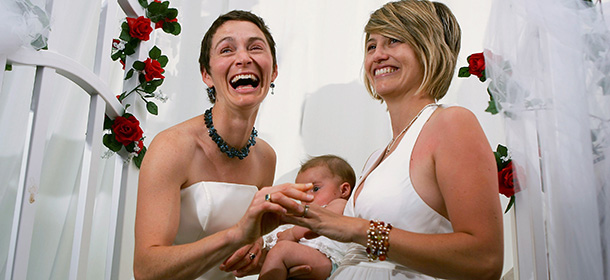 WEST HOLLYWOOD, CA - JUNE 17: Tori (L) and Kate Kendall, who already share the same last name, hold their five-month-old baby Zadie while being are joined in wedlock as the era of same-sex marriage begins in California, June 17, 2008 in West Hollywood, California. Conservative and religious groups hope that voters will support their initiative on the November ballot to alter the state constitution to permanently ban gay marriages. Meanwhile, many business owners are looking for a wedding related sales boom. A study released by University of California Los Angeles (UCLA) this month projects that nearly half of the state's 102,600 same-sex couples will marry in the next three years and, along with same-sex couples from other states, will spend more than $683 million on weddings, honeymoons and other marriage-related activities. (Photo by David McNew/Getty Images)