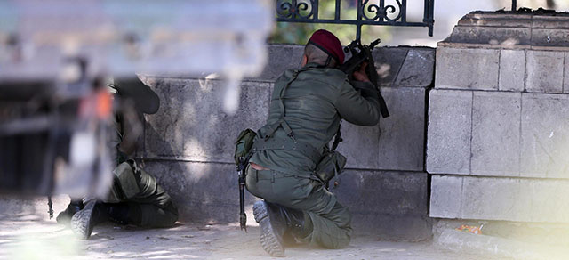 epa04667722 Members of the Tunisian armed forces take up positions after gunmen reportedly took hostages near the country's parliament, outside the National Bardo Museum, Tunis, Tunisia, 18 March 2015. According to local reports eight people were killed, mostly tourists, and many more wounded when gunmen attacked the popular Bardo museum, allegedly taking others hostage as members of the security services deploy around the museum's buildings prior to entering them, allegedly trading fire with the militants inside. EPA/MOHAMED MESSARA