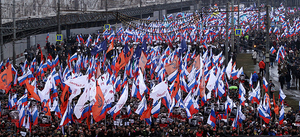 Russia's opposition supporters carry a banner bearing a portrait of Kremlin critic Boris Nemtsov and reading Heroes never die. These bullets in each of us during a march in central Moscow on March 1, 2015. The 55-year-old former first deputy prime minister under Boris Yeltsin was shot in the back several times just before midnight on February 27 as he walked across a bridge a stone's throw from the Kremlin walls. AFP PHOTO / SERGEI GAPON (Photo credit should read SERGEI GAPON/AFP/Getty Images)