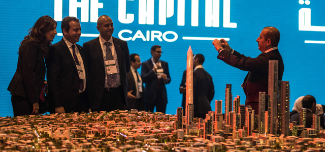 (150313) -- SHARM EL SHEIKH, March 13, 2015 (Xinhua) -- A man takes photos of delegates beside a model of planned new capital of Egypt during Egypt Economic Development Conference (EEDC) held in Sharm el Sheikh, a Red Sea resort city in South Sinai of Egypt, on March 13, 2015. Saudi Arabia, Kuwait and the United Arab Emirates (UAE) pledged on Friday a total of 12 billion U.S. dollars in aid and investment to boost Egypt's ailing economy at Egypt's Economic Development Conference (EEDC). 
 (Xinhua/Pan Chaoyue)