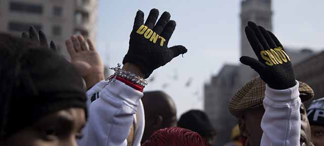 Lesley McSpadden (C), mother of Ferguson shooting victim Michael Brown, holds up her hands with gloves that say "Don't Shoot" during the "Justice For All" march in Washington, DC, December 13, 2014. Thousands of people descended on Washington to demand justice Saturday for black men who have died at the hands of white police, the latest in weeks of demonstrations across the United States. AFP PHOTO/JIM WATSON (Photo credit should read JIM WATSON/AFP/Getty Images)