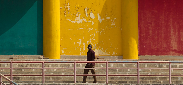 Un uomo cammina davanti a un muro dipinto coi colori della bandiera del Mali, nel 2012 (AP Photo/Rebecca Blackwell)