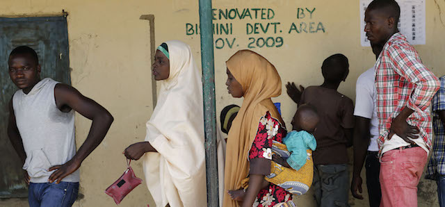 Nigerians wait to register before voting in Rejeina, some 80 kms (50 miles) from the capital Abuja, Nigeria Saturday, March 28, 2015. Nigerians went to the polls Saturday in presidential elections which analysts say will be the most tightly contested in the history of Africa's richest nation and its largest democracy. (AP Photo/Jerome Delay)