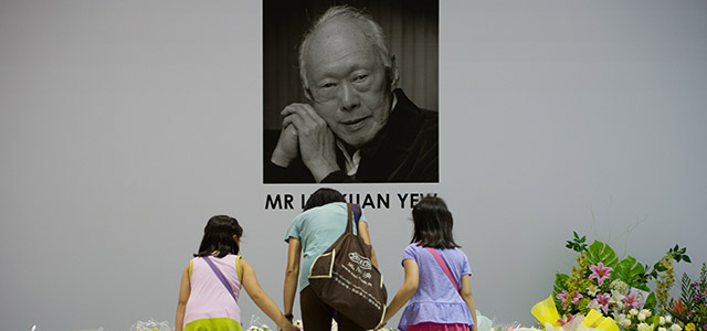 Singaporeans pray in front of an image of late former prime minister Lee Kuan Yew alongside messages and flowers left at the Tanjong Pagar community center following Lee's death in Singapore on March 23, 2015. Singapore's first prime minister Lee Kuan Yew, one of the towering figures of post-colonial Asian politics, died at the age of 91 on March 23 in hospital, the government said. AFP PHOTO / MOHD RASFAN (Photo credit should read MOHD RASFAN/AFP/Getty Images)