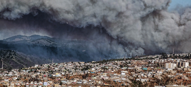 Smoke billows from the forest around Valparaiso, in Chile, on March 13, 2015 as the fire threatens to reach the city's port. Authorities have declared a red alert in the area. AFP PHOTO / FRANCESCO DEGASPERI (Photo credit should read FRANCESCO DEGASPERI/AFP/Getty Images)