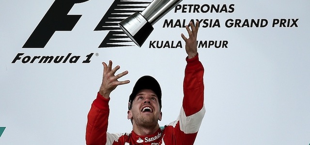 Sebastian Vettel della Ferrari esulta sul podio lanciando per aria il trofeo (MANAN VATSYAYANA/AFP/Getty Images)
