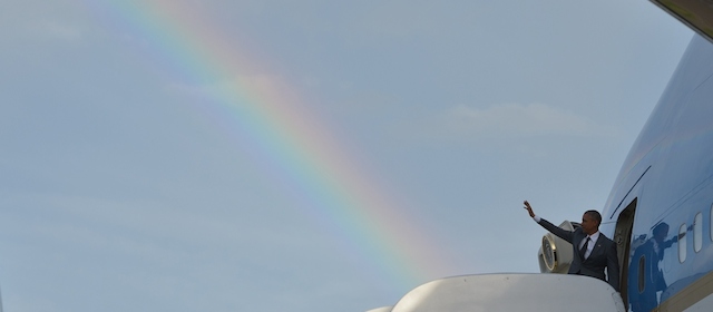 US President Barack Obama makes his way to board Air Force One under a rainbow upon departure from Kingston, Jamaica on April 9, 2015. Obama is heading to Panama to attend the Summit of the Americas. AFP PHOTO/MANDEL NGAN (Photo credit should read MANDEL NGAN/AFP/Getty Images)