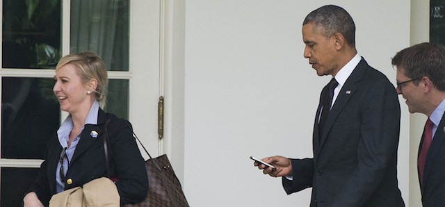 US President Barack Obama uses a cellphone as he walks to the West Wing of the White House alongside White House Deputy Chief of Staff for Operations Anita Decker Breckenridge (L) and Press Secretary Jay Carney (R) after arriving back at the White House in Washington, DC, May 15, 2014. The Obamas are returning from New York City where they attended the dedication ceremony of the National September 11 Memorial and Museum. AFP PHOTO / Saul LOEB (Photo credit should read SAUL LOEB/AFP/Getty Images)