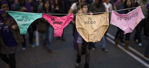 People march as they carry underwear that reads: "I Decide" during a protest against the Spanish government plan to implement major restrictions on abortion and to fight for woman's rights on International Women's Day in Madrid, Spain, Saturday, March 8, 2014. (AP Photo/Andres Kudacki)