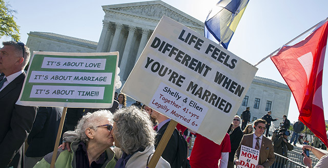 Shelly Bailes, 74, left, and her wife, Ellen Pontac, 73, both of Davis, Calif., kiss in front of the Supreme Court in Washington, Tuesday, April 28, 2015. The Supreme Court is set to hear historic arguments in cases that could make same-sex marriage the law of the land. The justices are meeting to offer the first public indication of where they stand in the dispute over whether states can continue defining marriage as the union of a man and a woman, or whether the Constitution gives gay and lesbian couples the right to marry. (AP Photo/Cliff Owen)