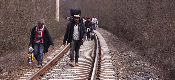 In this Saturday, Feb. 28, 2015 photo West African migrants walk on train tracks on their way towards the border with Macedonia near the town of Evzonoi, Greece. The tide of hopeful migrants pours through the vulnerable 'back-door' countries in the hope of entering the 28-nation European Union, and although most people don't make it, the human tide continues to grow, according to Frontex, the EU agency that helps governments police the bloc’s leaky frontiers. (AP Photo/Dalton Bennett)