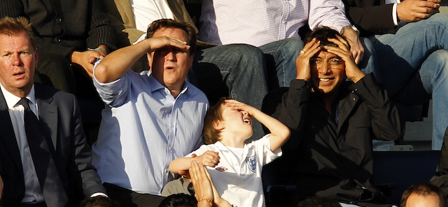 Britain's Prime Minister and Aston Villa supporter David Cameron, top second left, reacts as he sits with his son Arthur, flanked by Queens Park Rangers part-owner and Indian steel magnate Lakshmi Mittal, right, during the English Premier League soccer match between Queens Park Rangers and Aston Villa at Loftus Road stadium in London, Sunday, Sept. 25, 2011. (AP Photo/Matt Dunham)