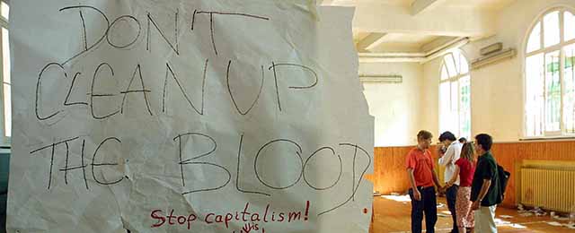 (FILES) This file picture taken on July 22, 2001 at a school in Genoa during a Group of Eight summit shows a note reading "Don't Clean Up The Blood" hanging in the headquarters of the umbrella anti-globalisation protest movement, the Genoa Social Forum (GSF) after an overnight police raid in Genoa. Genoa's tribunal condemned on November 13, 2008 13 Italian policemen for a total of 35 years and seven months of jail for the violence which took place at the Diaz school which was used as a dormitory by anti-globalists activists during the summit. 16 other policemen, including the three in charge of the security of the summit were acquitted. AFP PHOTO/FILES/GERARD JULIEN (Photo credit should read GERARD JULIEN/AFP/Getty Images)