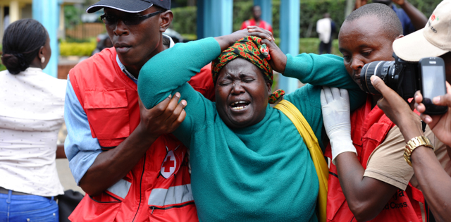 Kenya Red Cross staff assist a woman after she viewed the body of a relative killed in Thursday's attack on a university, at Chiromo funeral home, Nairobi, Kenya, Friday, April 3, 2015. Al-Shabab gunmen rampaged through a university in northeastern Kenya at dawn Thursday, killing scores of people in the group's deadliest attack in the East African country. Four militants were slain by security forces to end the siege just after dusk. (AP Photo)