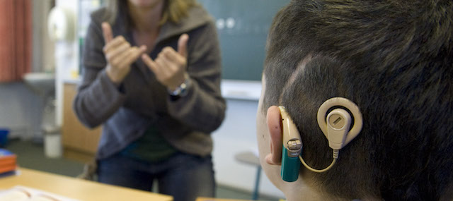 Un ragazzo con impianto cocleare segue una lezione in lingua dei segni alla scuola per sordi di Halberstadt, in Germania, il 21 maggio 2009. 
(AP Photo/Eckehard Schulz)