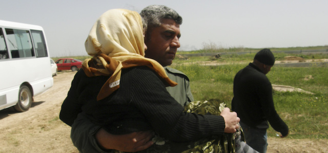 A man carries a Yazidi released by Islamic State group militants as she arrives in Kirkuk, 180 miles (290 kilometers) north of Baghdad, Iraq, Wednesday, April 8, 2015. The Islamic State group released more than 200 Yazidis on Wednesday after holding them for eight months, an Iraqi Kurdish security official said, the latest mass release of captives by the extremists. (AP Photo)