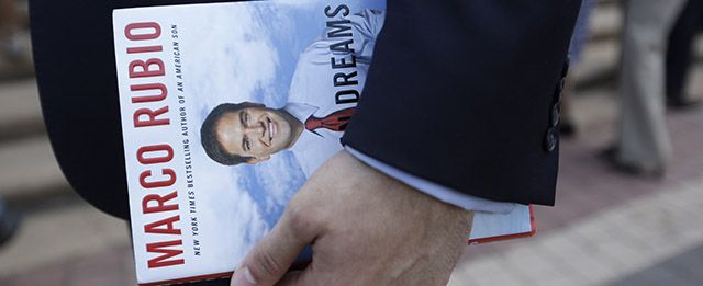 A man holds a book written by Sen. Marco Rubio as he waits in line for the doors to open outside of the Freedom Tower where Rubio is launching his Republican presidential campaign, Monday, April 13, 2015, in Miami. (AP Photo/Lynne Sladky)