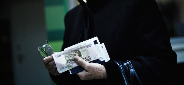An elderly woman holds her pension received in Russian ruble notes in the eastern Ukrainian city of Donetsk on April 1, 2015. The year-long conflict in east Ukraine has closed businesses across the industrial heartland, ramping up unemployment, crippling its financial sector and leaving it ever more reliant on Moscow. AFP PHOTO / DIMITAR DILKOFF (Photo credit should read DIMITAR DILKOFF/AFP/Getty Images)