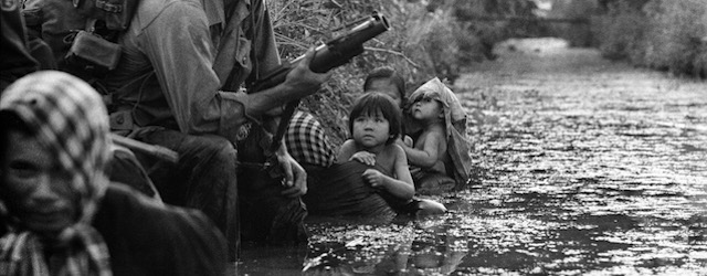 Bambini sudvietnamiti guardano un soldato americano con in mano un lancia-granate a Bao Trai, 1 gennaio 1966. 
(AP Photo/Horst Faas)