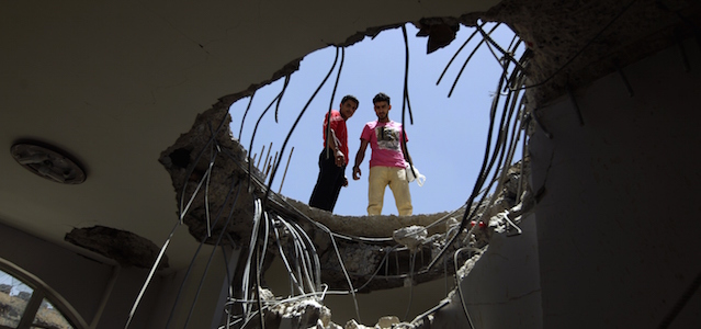 Yemenis look down through a hole in the roof of a house which was damaged the day before during an air strike by Saudi-led coalition warplanes on the nearby base on Fajj Attan hill on April 21, 2015 in the capital Sanaa. At least 38 civilians were killed in explosions that followed the air strike on the base on Fajj Attan hill that belongs to the missile brigade of the elite Republican Guard, which remains loyal to former president Ali Abdullah Saleh. AFP PHOTO / MOHAMMED HUWAIS (Photo credit should read MOHAMMED HUWAIS/AFP/Getty Images)