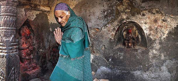 An elderly Nepalese woman prays at a temple damaged in an earthquake in Kathmandu, Nepal, Friday, May 1, 2015. The strong magnitude earthquake shook Nepal on Saturday devastating the region and leaving some thousands shell-shocked and displaced. (AP Photo/Manish Swarup)