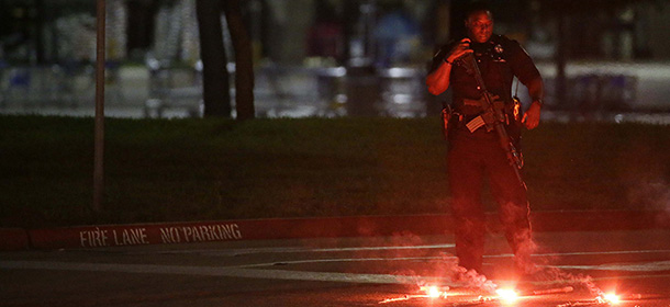 An armed police officer stands guard at a parking lot near the Curtis Culwell Center where a provocative contest for cartoon depictions of the Prophet Muhammad was held Sunday, May 3, 2015, in Garland, Texas. The contest was put on lockdown Sunday night and attendees were being evacuated after authorities reported a shooting outside the building. (AP Photo/LM Otero)