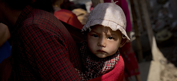 Nepalese infant is carried on the back of her mother before getting a vaccination in Lapsiphedi, near Kathmandu, Nepal, Monday, May 4, 2015. A campaign’s underway in Nepal to immunize half a million children against measles and rubella in the wake of the earthquake. Concern’s growing that with so many people made homeless there is the potential for an outbreak of the potentially fatal diseases. The United Nation’s Children’s Fund – UNICEF – has been working to eliminate them for years but 1 in 10 is still not immunized. (AP Photo/Bernat Amangue)
