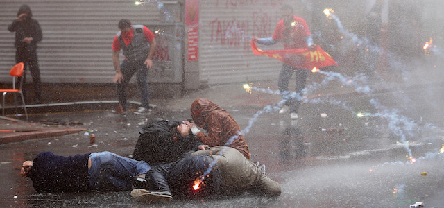 Manifestanti cercano di proteggersi dai gas lacrimogeni e dall'acqua sparata dai cannoni della polizia a Istanbul, 1 maggio 2015. 
(AP Photo/Emrah Gurel)