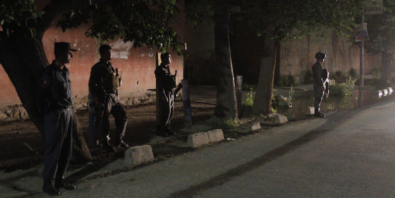 Afghan policemen stand guard near the Park Place Hotel in Kabul, Afghanistan, Thursday, May 13, 2015. Gunmen stormed the guesthouse on Wednesday night as it hosted a party for foreigners. An hourslong siege ended early Thursday morning. (AP Photo/Allauddin Khan)