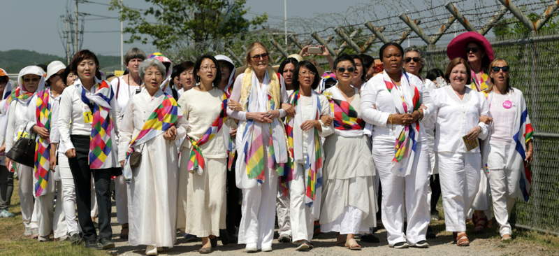 Gloria Steinem, sesta da destra, Mairead Maguire, seconda da destra, Leymah Gbowee, terza da destra, e altre attiviste mentre provano ad attraversare il confine. (AP Photo/Lee Jin-man)