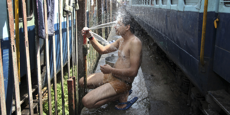 Un passeggero di un treno indiano si sciacqua con dell'acqua alla stazione ferroviaria di Jammu, India, 25 maggio 2015.
(AP Photo/Channi Anand)