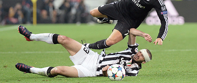 Real Madrid Cristiano Ronaldo is tackled by Juventus' Giorgio Chiellini during the Champions League, semifinal soccer match between Juventus and Real Madrid at the Juventus Stadium in Turin, Italy, Tuesday, May 5, 2015. (AP Photo/Massimo Pinca)
