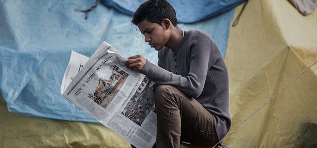 An earthquake survivor reads a newspaper at a shelter camp in Kathmandu on April 29, 2015, following a 7.8 magnitude earthquake which struck the Himalayan nation on April 25. Rescuers are facing a race against time to find survivors of a mammoth earthquake that killed more than 5,000 people when it through Nepal five days ago and devastated large parts of one of Asia's poorest nations. AFP PHOTO / Philippe Lopez (Photo credit should read PHILIPPE LOPEZ/AFP/Getty Images)