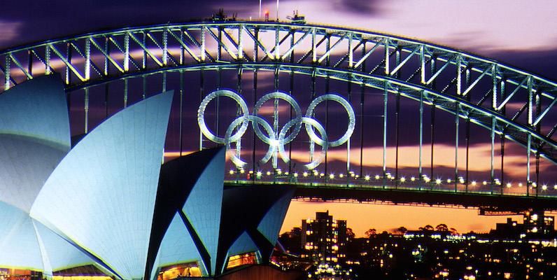 30 Aug 2000: (FILE PHOTO) Sunset over the Olympic Rings on the Sydney Harbour Bridge and the Opera House as the Olympic Games loom on Sydney Harbour, Sydney, Australia. October 20th, 2003 marks the 30th Anniversary of the Sydney Opera House. The Opera house was designed by Danish architect Jorn Utzon and was opened by Queen Elizabeth II on October 20, 1973. (Photo by Nick Wilson/Getty Images).