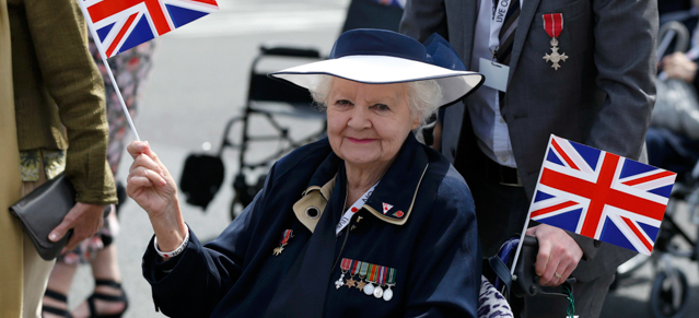Una veterana sventola la bandiera britannica alla parata. (Phil Noble/PA Wire)