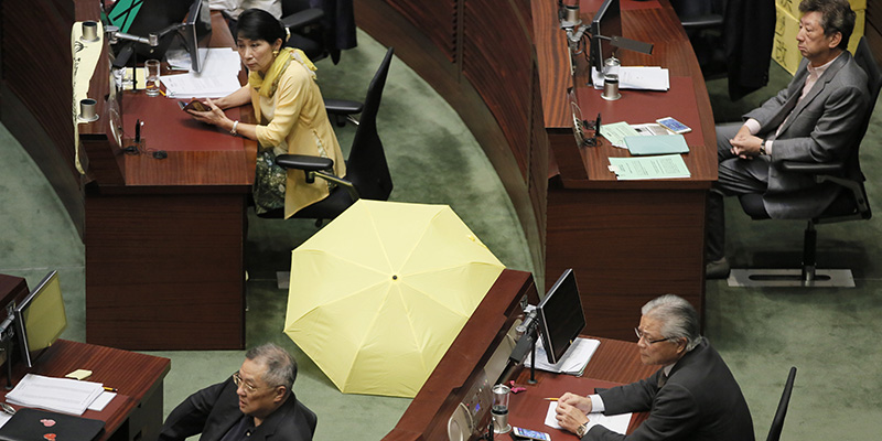 La deputata pro-democrazia Claudia Mo con un ombrello giallo prima del voto in aula sulla riforma chiesta da Pechino, 18 giugno 2015 (AP Photo/Vincent Yu)