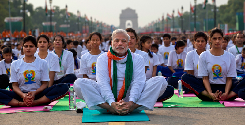 Il primo ministro indiano Narendra Modi fa yoga con altri migliaia di indiani sul grande viale Rajpath, a Nuova Delhi. (AP Photo/Saurabh Das)
