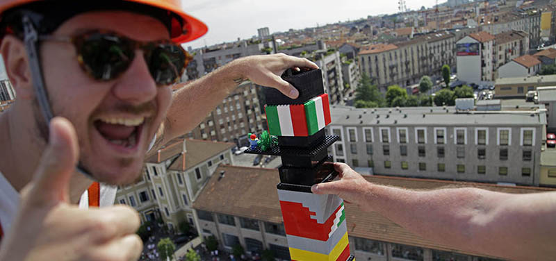Il presentatore televisivo Alessandro Cattelan mentre sistema l'ultimo pezzo sulla torre (Lego)