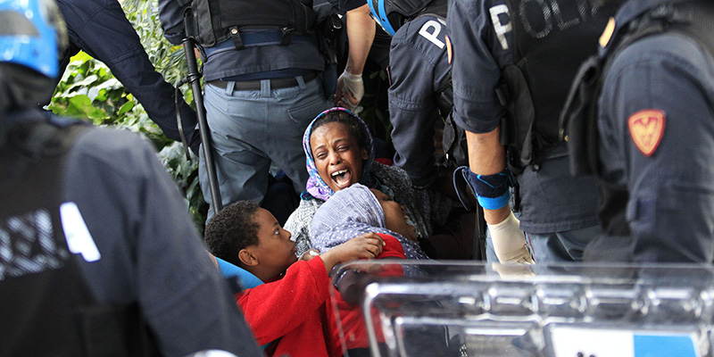 La polizia sposta con la forza alcuni migranti a Ventimiglia, il 16 giugno. (CHRISTOPHE MAGNENET/AFP/Getty Images)
