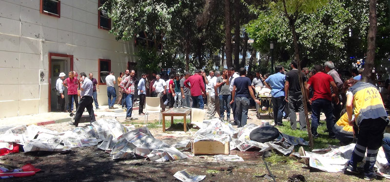 Alcuni corpi sono coperti da fogli di giornale al centro culturale di Suruc (AP Photo)