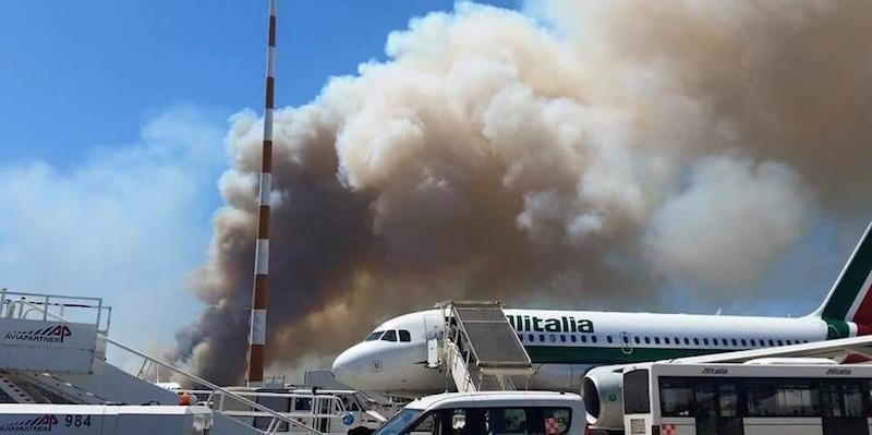 Una grossa colonna di fumo nell'Aeroporto di Fiumicino, vicino Roma. Poco dopo l'ora di pranzo è scoppiato un grande incendio nella pineta alle spalle dello scalo Leonardo Da Vinci: alcune piste sono state chiuse ed è stato disposto il blocco dei decolli
(LaPresse)
