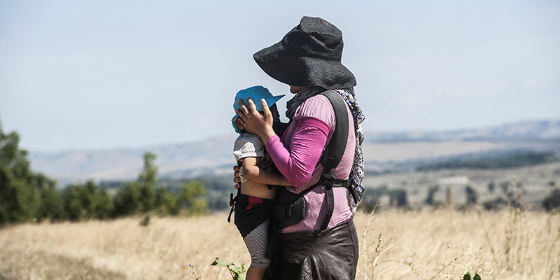 Una donna con il suo bambino in viaggio dalla Macedonia alla Serbia, 25 agosto 2015 (ARMEND NIMANI/AFP/Getty Images)