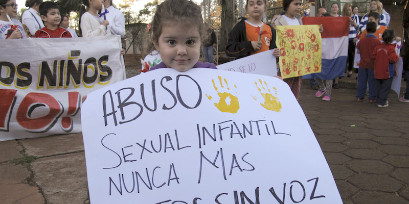 Una bambino con un cartello con scritto "Mai più abusi sessuali sui bambini", a una manifestazione davanti all'ufficio del procuratore generale di Ciudad del Este, in Paraguay, 11 maggio 2015.
(AP Photo/Peter Prengaman)