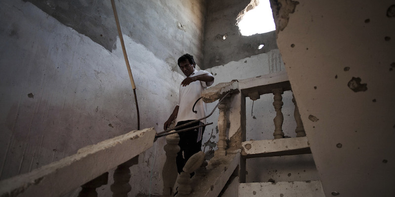 Un uomo nella sua casa danneggiata da alcuni bombardamenti a Sirte , Libia. (AP Photo/Manu Brabo)