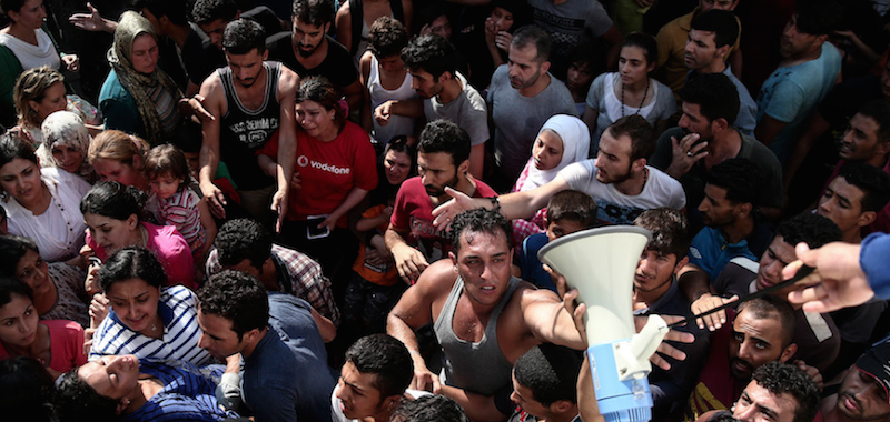 Centinaia di persone in coda per la registrazione nello stadio di Kos. (AP Photo/Yorgos Karahalis)