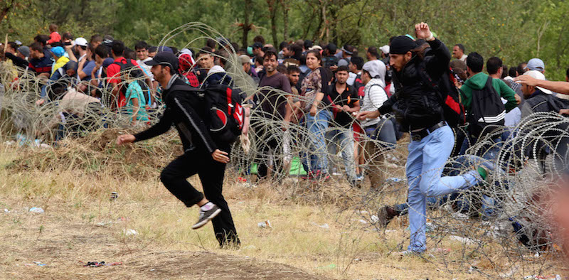 Alcuni migranti scavalcano il filo spinato ed entrano in Macedonia, 22 agosto 2015 (AP Photo/Vlatko Perkovski)